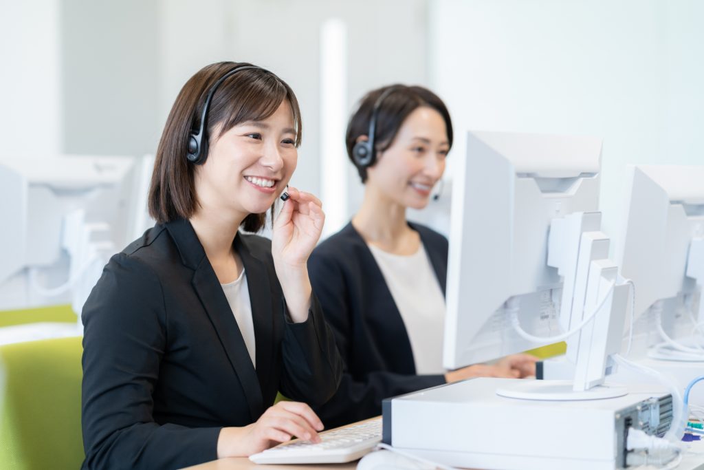 笑顔で電話応対をするコールセンターの女性オペレーター