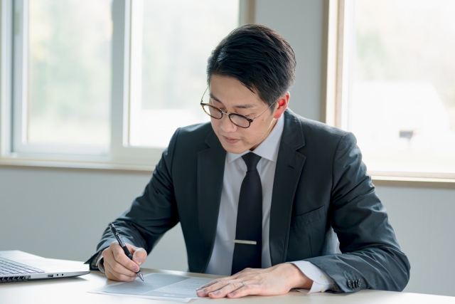 書類を書き込むビジネスマン