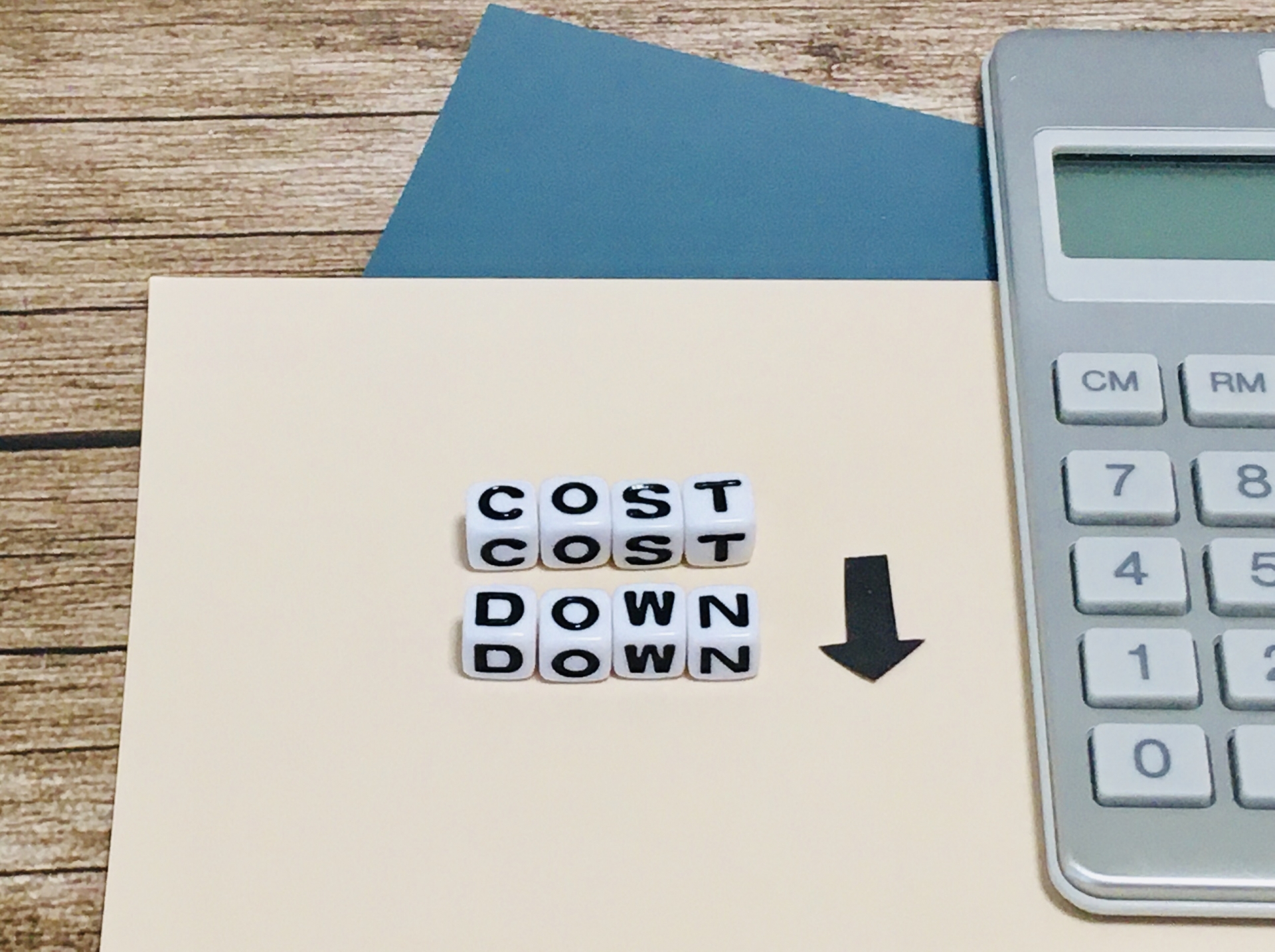 COSTDOWNと書かれたキューブと下向き矢印